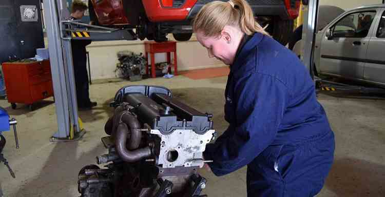 A woman fixing an engine